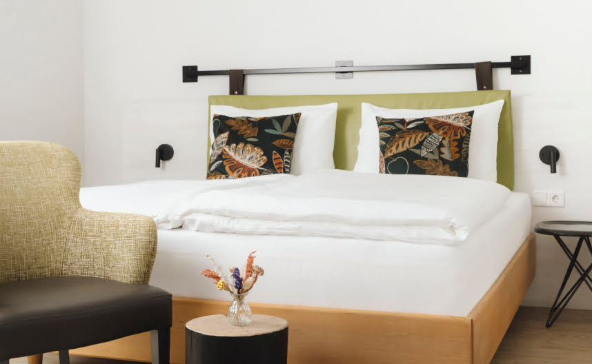 A comfortable bed with a bedside table and seating area.